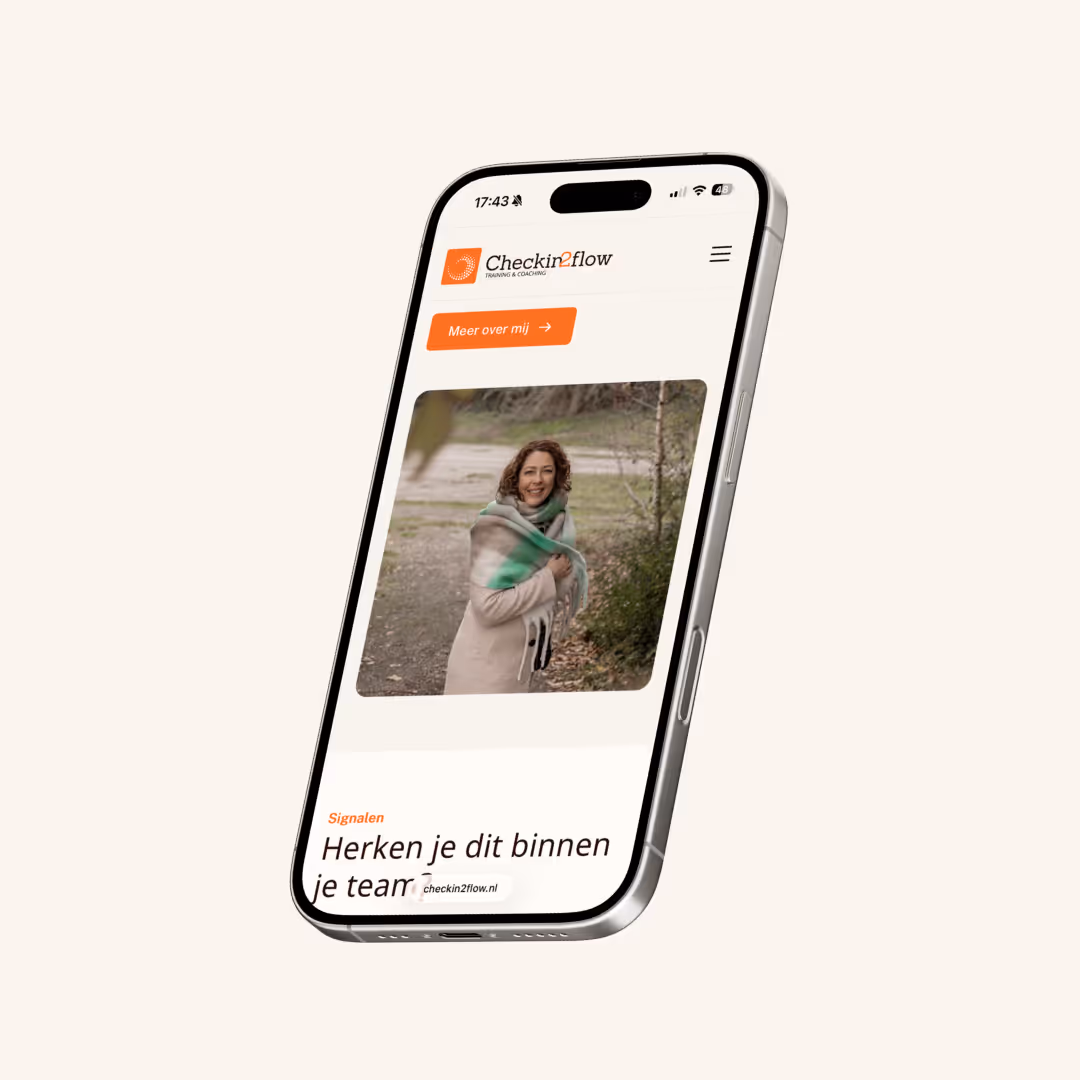 Een mobiele telefoon toont een website met een vrouw in een beige jas en groene sjaal buiten.