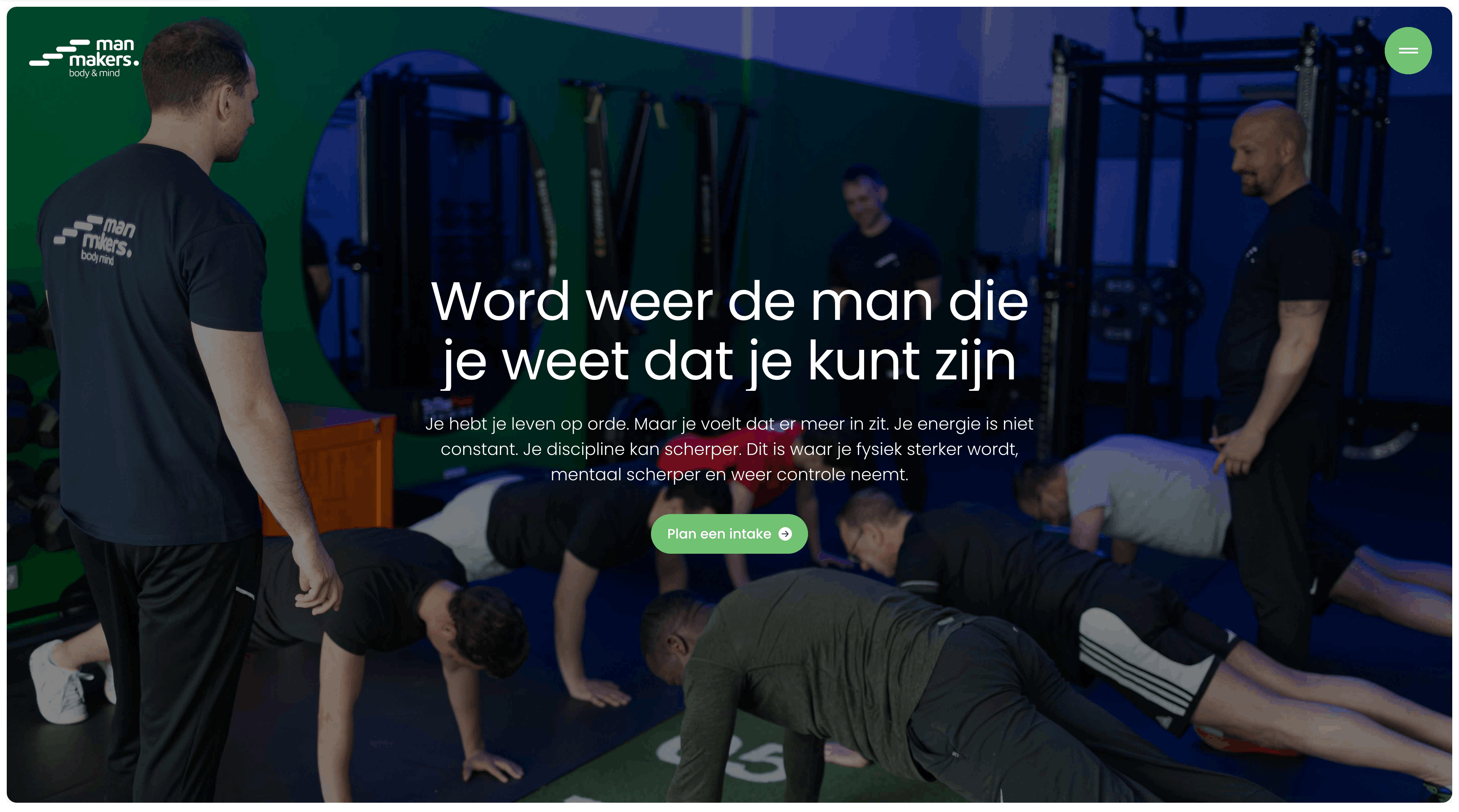 Een groep mannen doet push-ups onder begeleiding in een sportschool met blauwe en groene muren.