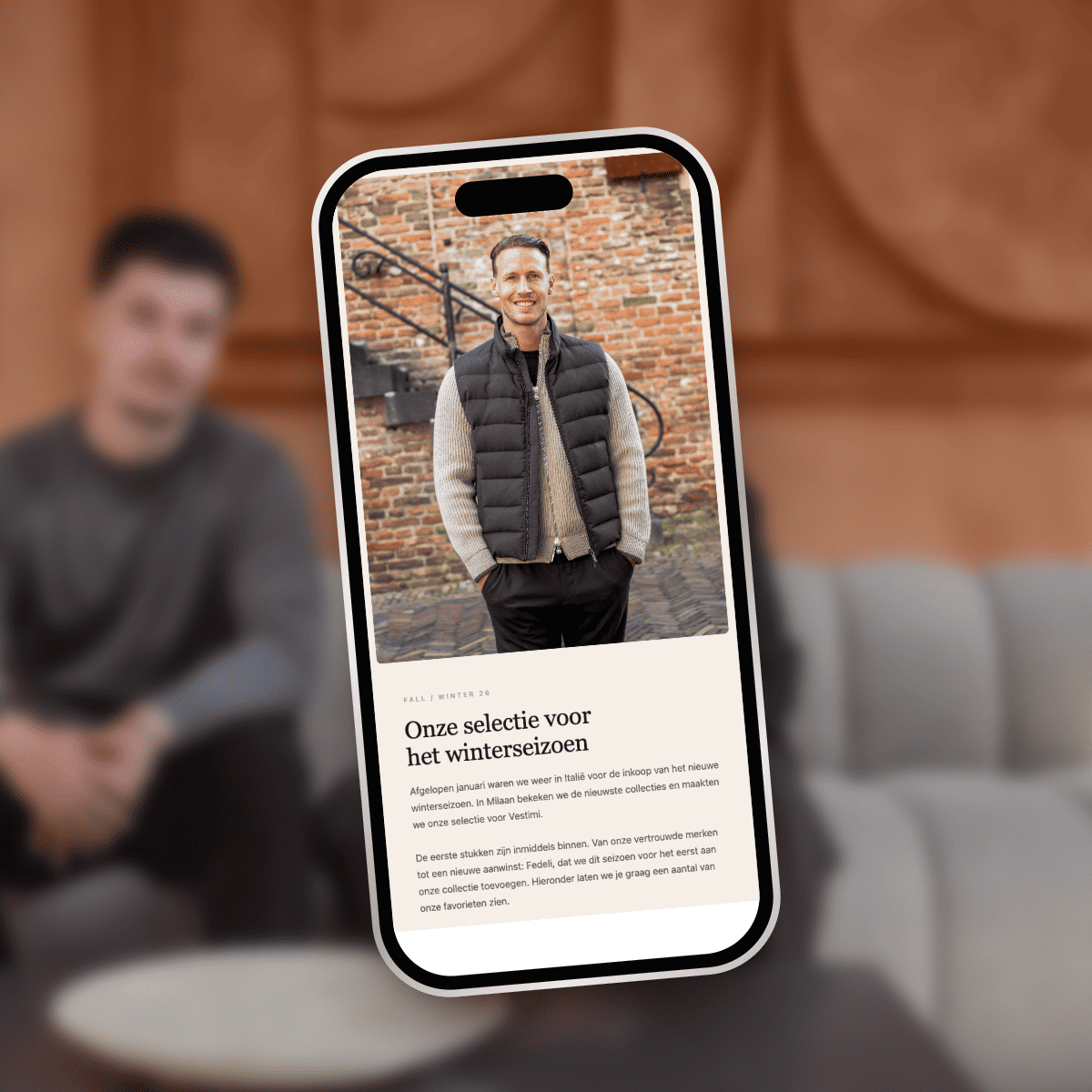 Telefoon met een e-mailcampagne voor een menswear-merk, op de achtergrond een van de oprichters van KS Vision.
