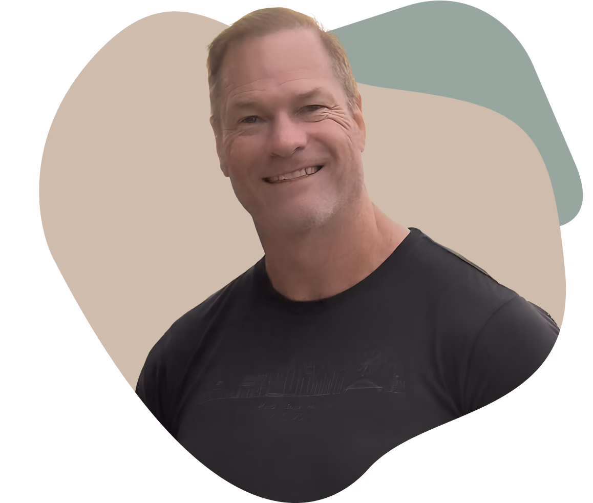 Smiling Dr. Shawn Baker, with short light brown hair wearing a black T-shirt.
