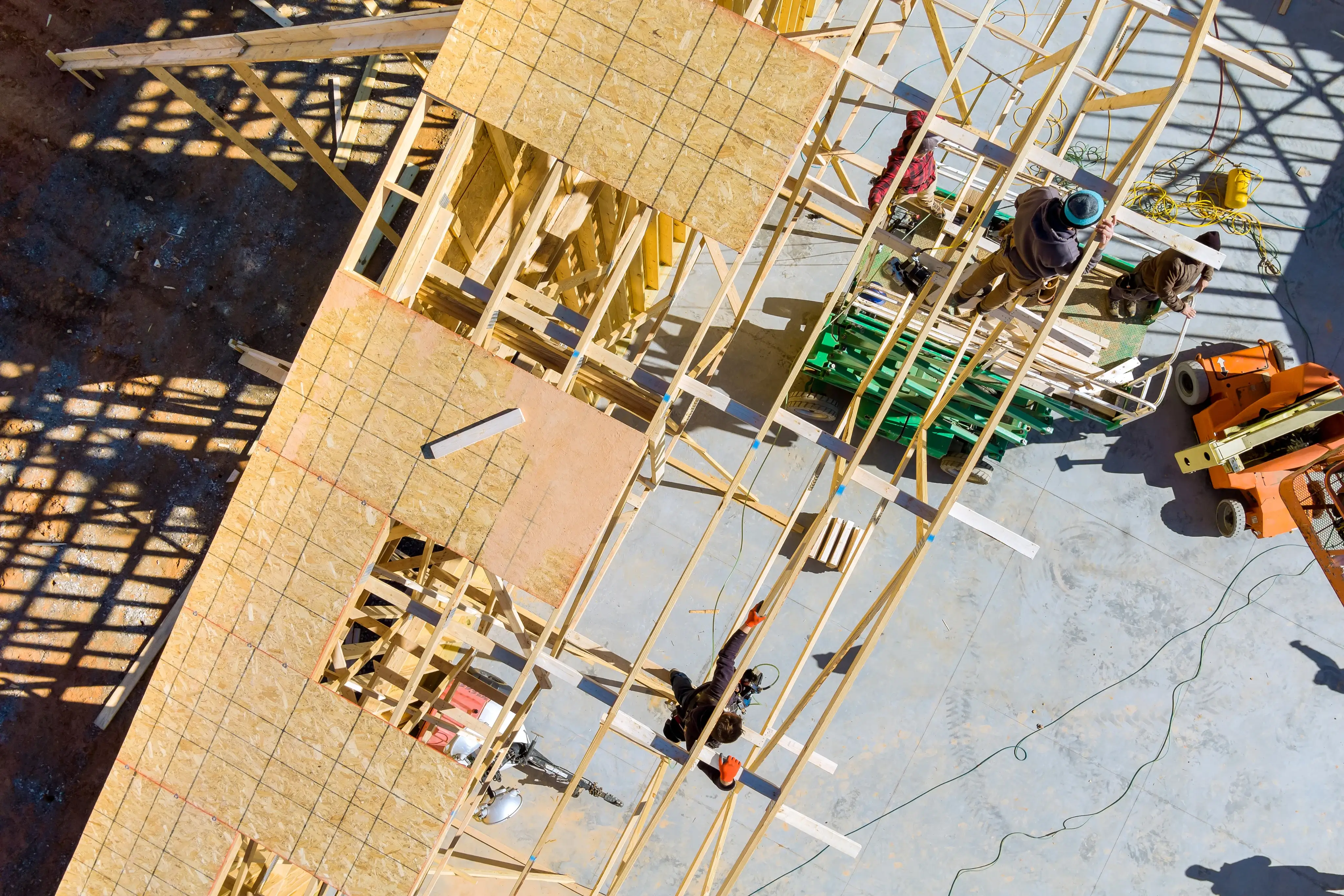 Aerial view of workers framing a building structure at a construction site