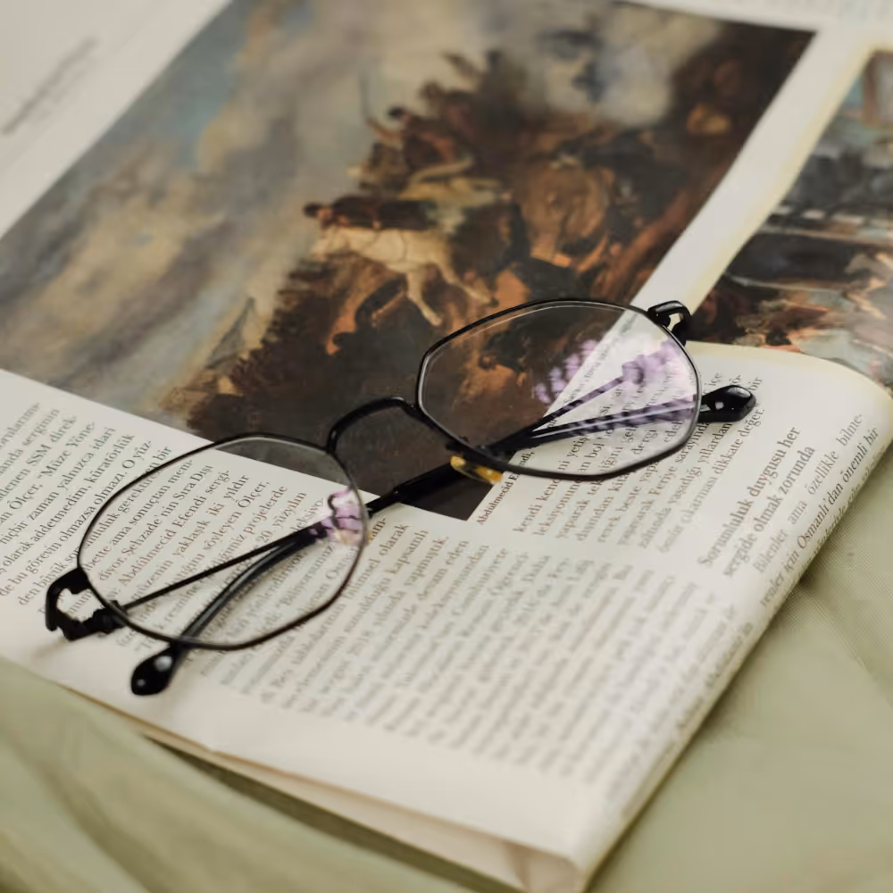 A pair of reading glasses upon a newspaper.