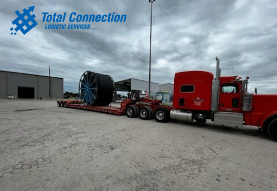 Oversized reel on a red lowboy trailer at the Baytown yard
