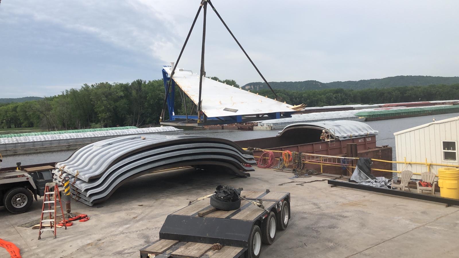 Plant vessel rigged to the crane above a step deck trailer at Winona