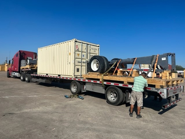 Rig component and container strapped on a flatbed at the wash yard