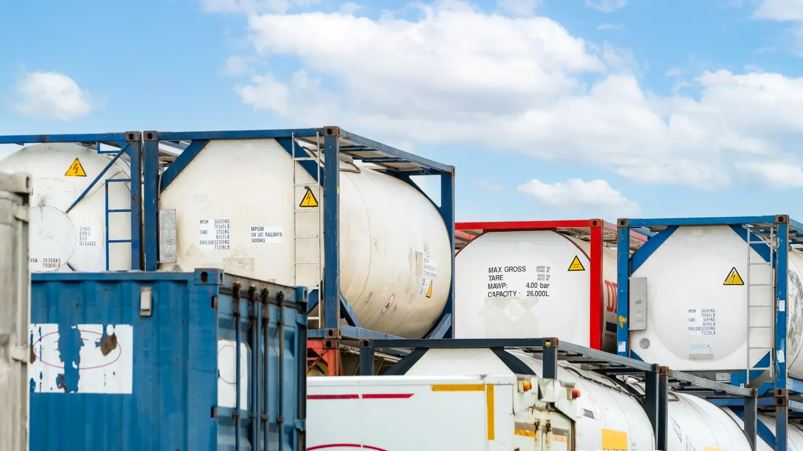 Row of ISO tank containers in a depot yard awaiting previous cargo and cleaning verification