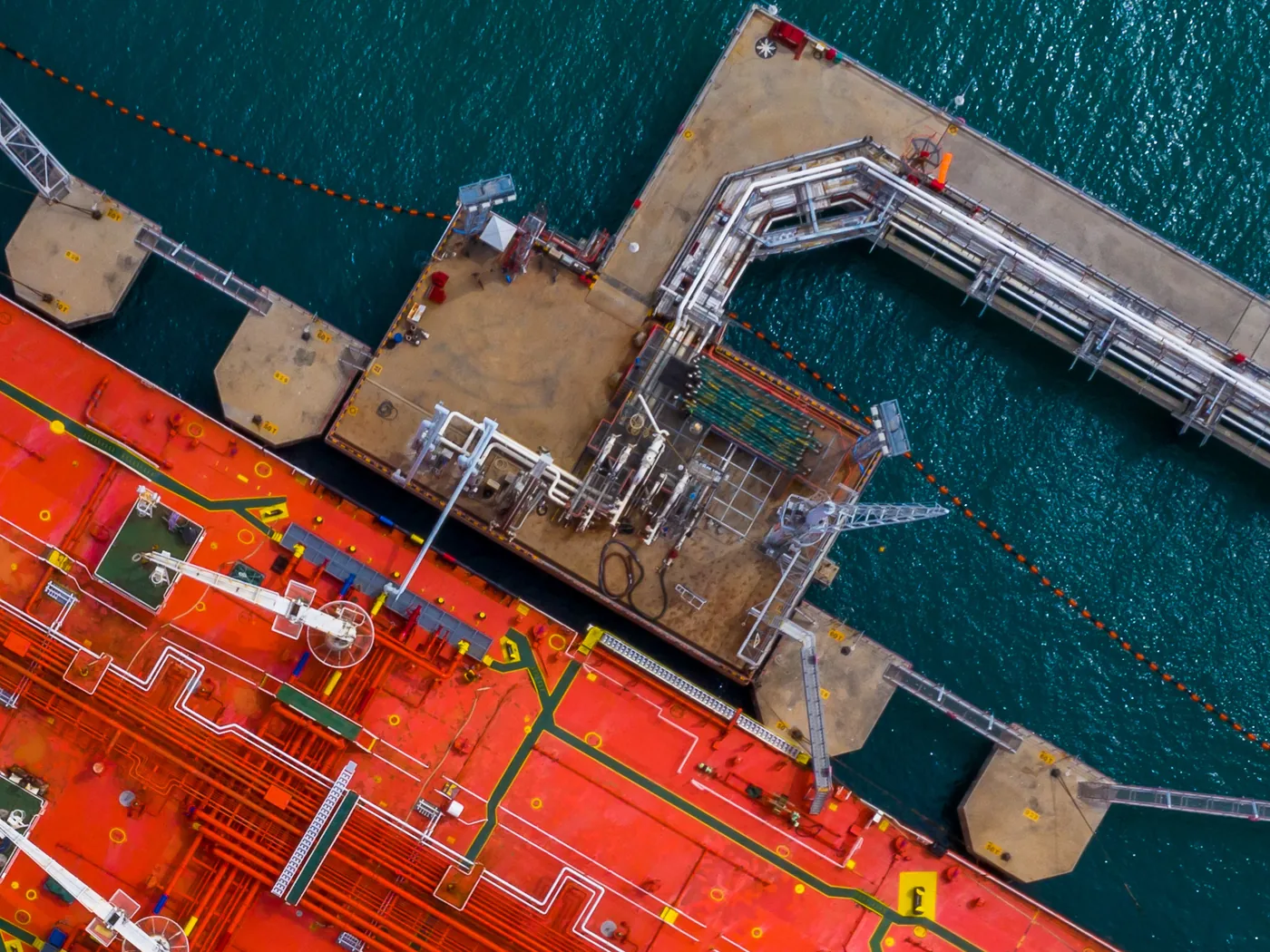 Oil tanker manifold connected to jetty loading arms, seen from above