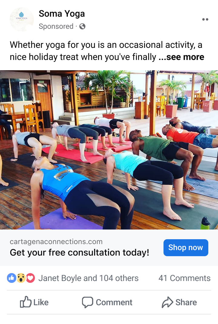 A group of people practicing yoga on mats indoors, performing a bridge pose with hands and feet on the floor and hips lifted.