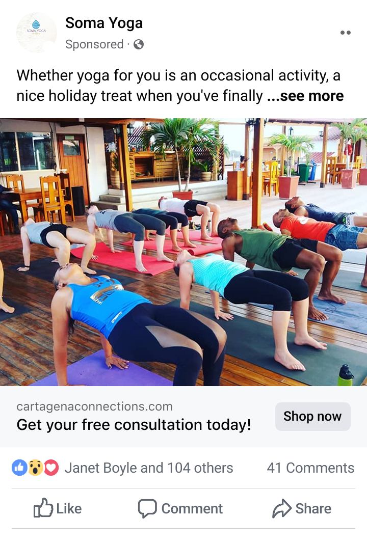 Group of people practicing yoga on mats indoors, performing reverse tabletop pose on wooden floor in a tropical-style room.