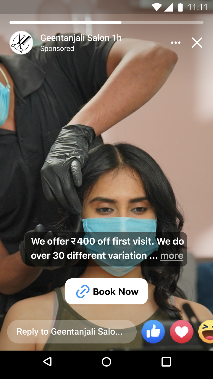 Person wearing a blue face mask getting a haircut from a stylist wearing black gloves and a black shirt.