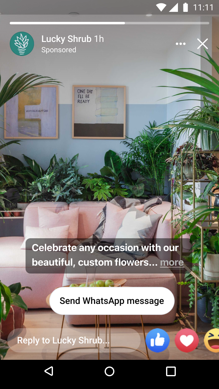 Cozy living room with pink sofa, decorative pillows, green plants, and framed wall art including one saying 'ONE DAY I'LL BE READY'.