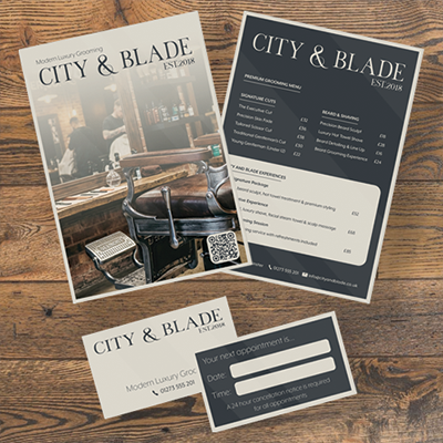 City & Blade modern luxury grooming brochure, price list, and appointment card on wooden surface.