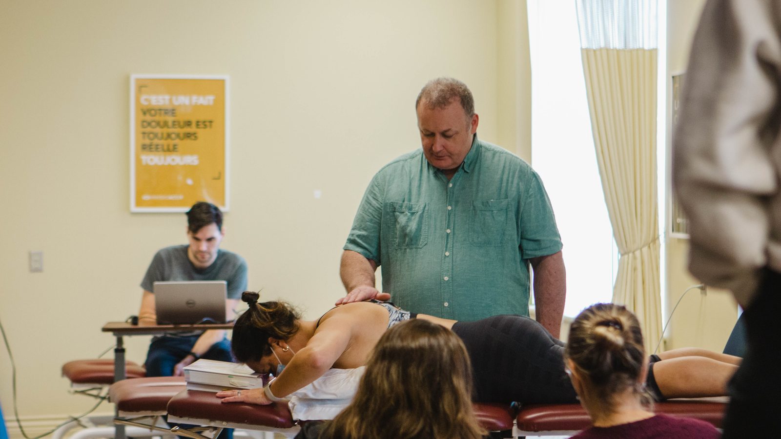 Formation Sean Gibbons: l'instructeur applique une technique manuelle sur le rachis thoracique d'un patient en décubitus ventral