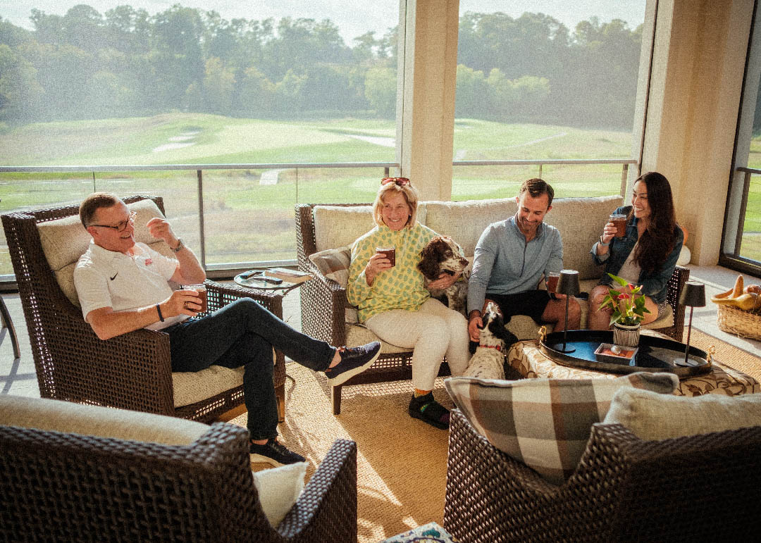 Family and their dog relaxing in a screened porch overlooking a golf course