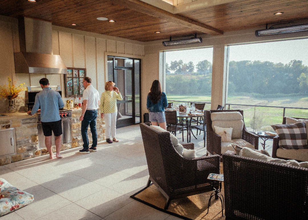 Family gathered in an open-air kitchen and living space overlooking a golf course