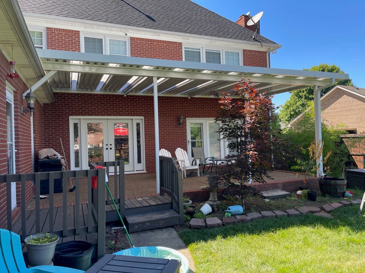 Aluminum louvered patio cover attached to a brick home