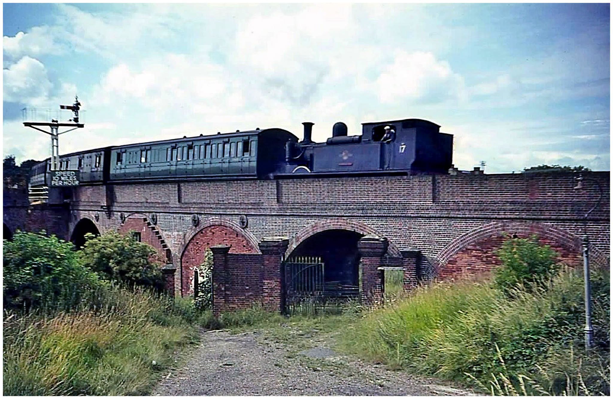 Sid Sponheimer took this on a visit to the Island in the latter half of July 1965, from a rather unusual vantage point, as W17 'Seaview' left Newport, Ryde-bound, and headed its train around the curving viaduct towards the short tunnel beneath Fairlee Road.