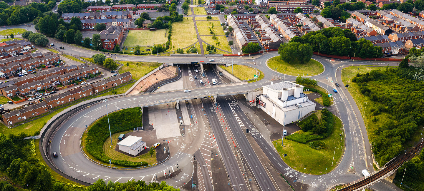 Aerial view of a road interchange leading to a tunnel entrance