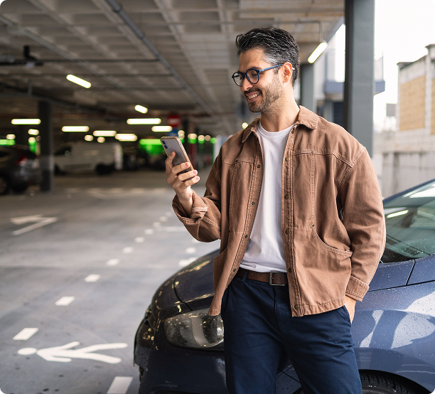 Man checking his phone in a multi-storey car park