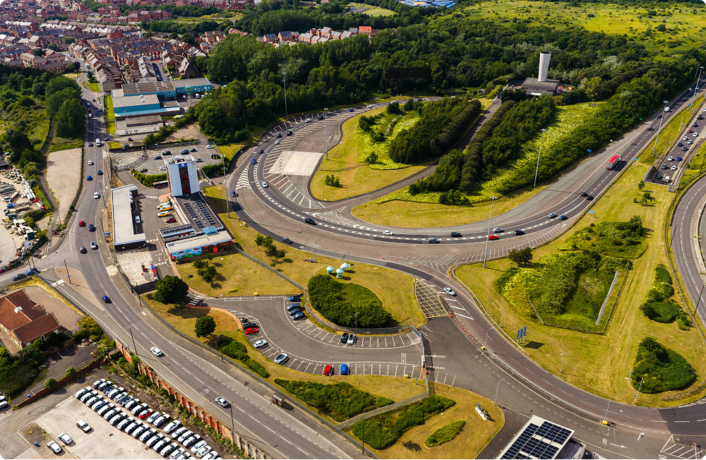 Aerial view of a road interchange with traffic on curving slip roads beside a town