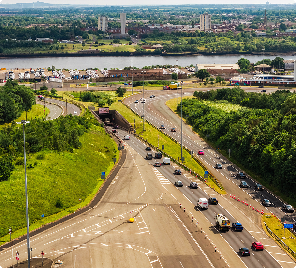 Aerial view of traffic approaching a road tunnel entrance beside a river