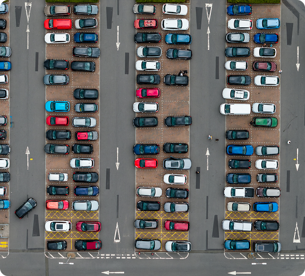 Top-down view of a full car park with rows of parked cars