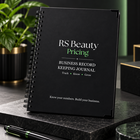 Business Record Keeping Journal on a dark marble stand with a green pen