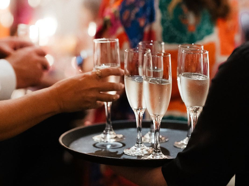 glasses of champagne being served on a tray