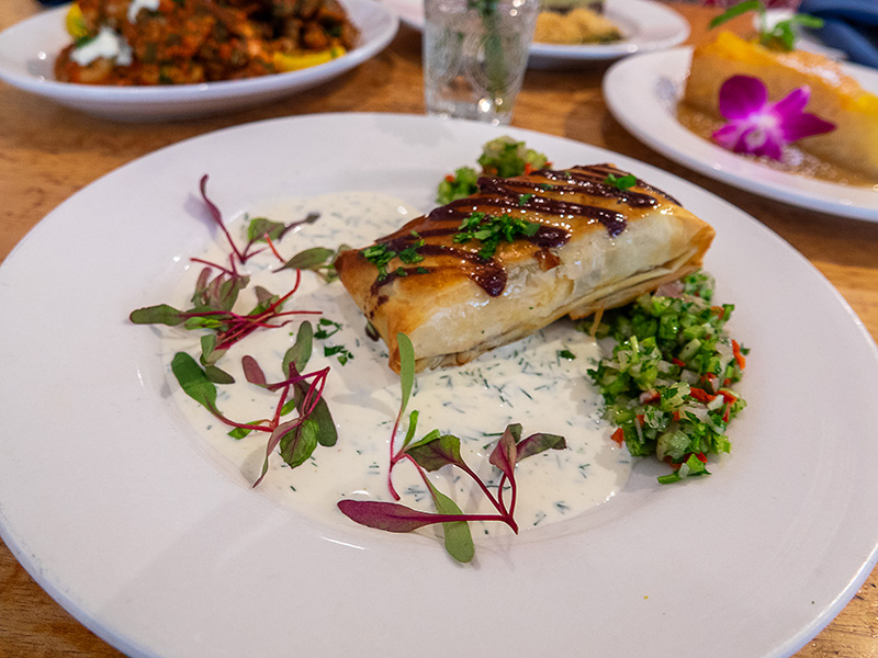 a plate of phyllo-wrapped salmon and greens in a cream sauce
