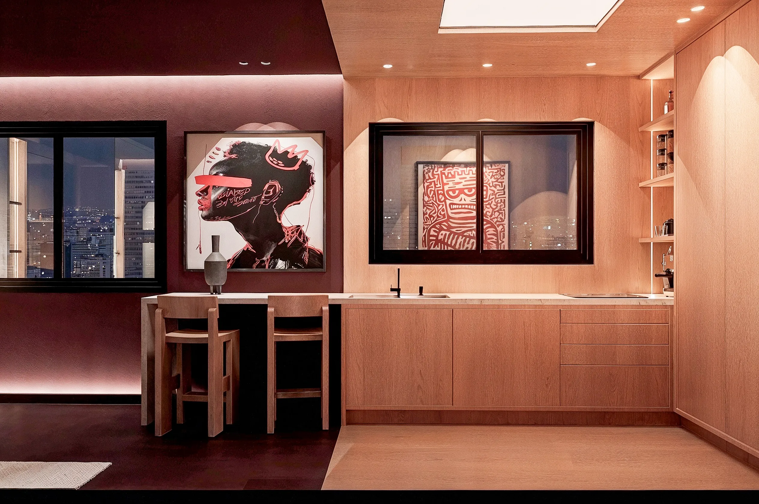 Cuisine compacte en bois sous des œuvres graphiques — studio 40 m², Paris