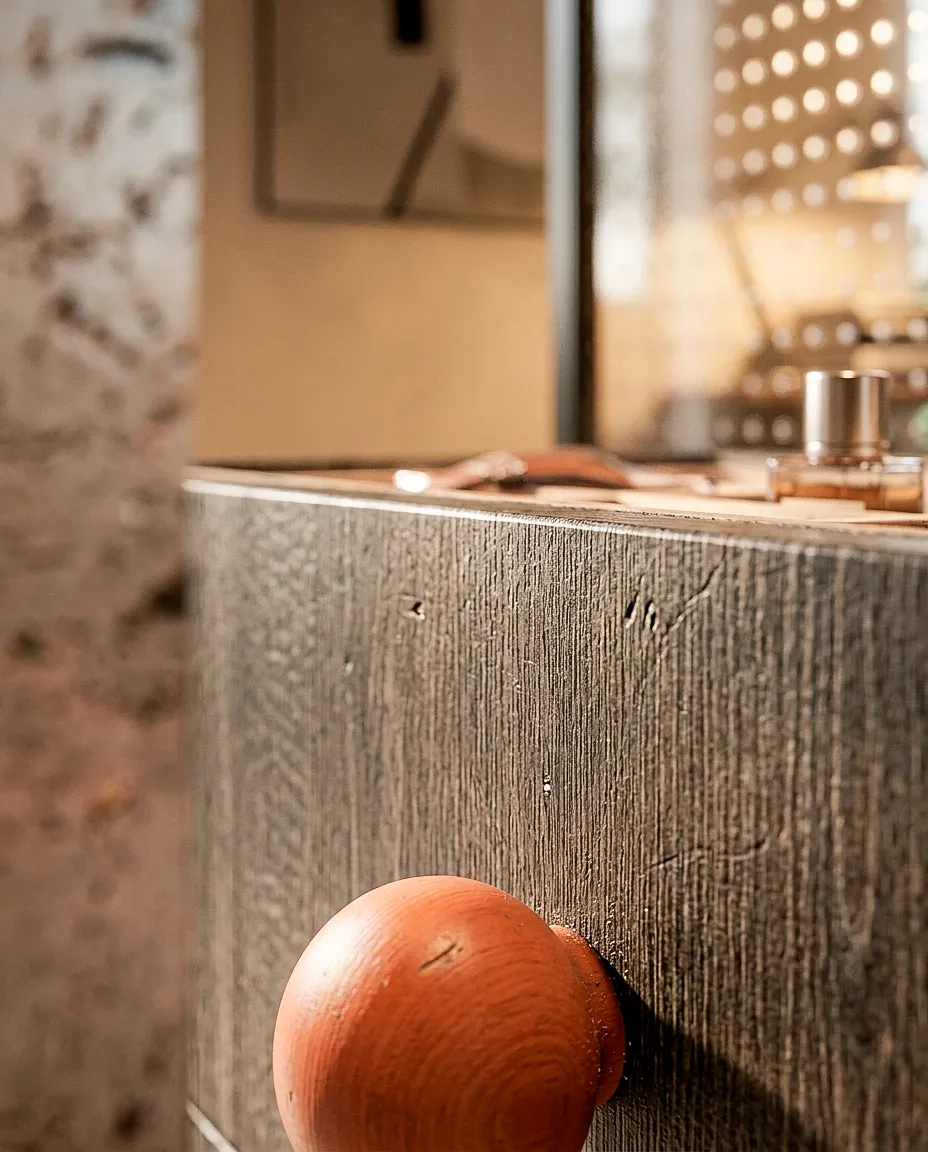 Détail d’un meuble en bois sombre et d’un objet sphérique — appartement 90 m²