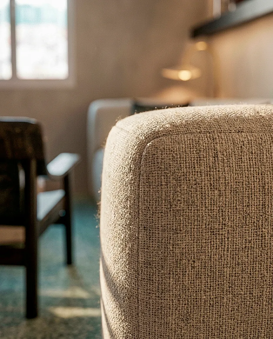 Détail d’un fauteuil au tissu clair — appartement 90 m²