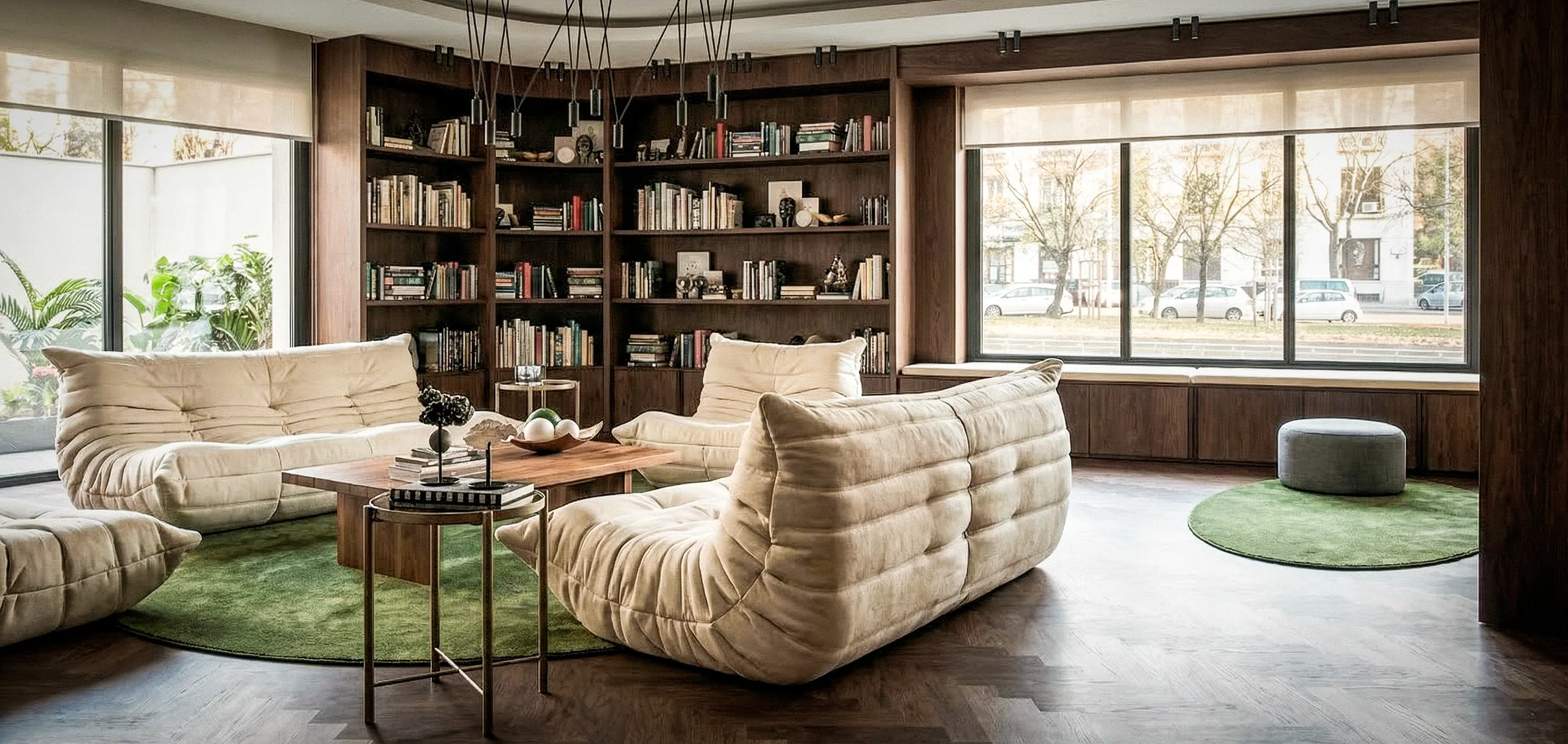 Salon avec canapés clairs, tapis vert et bibliothèque intégrée autour des fenêtres — appartement 160 m², Paris