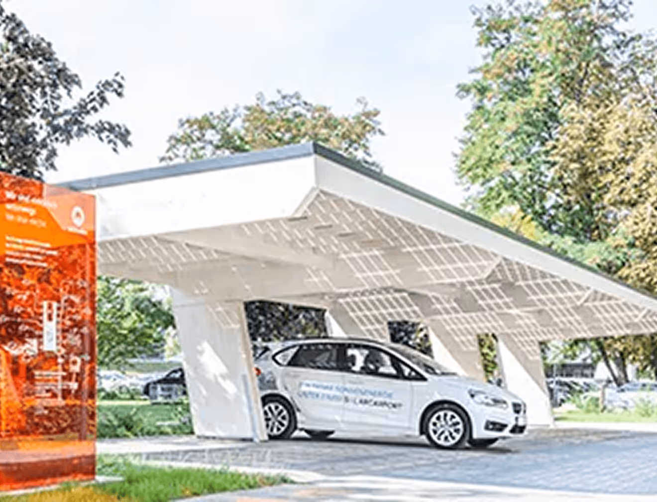 Weißes Elektroauto unter futuristischem Solardach in grünem Parkumfeld.