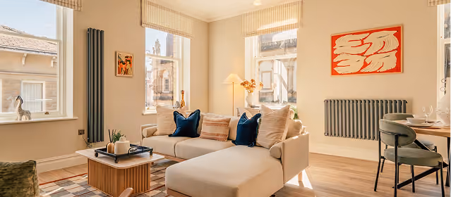Bright living room with sofa and dining table at St James Apartments, central Harrogate