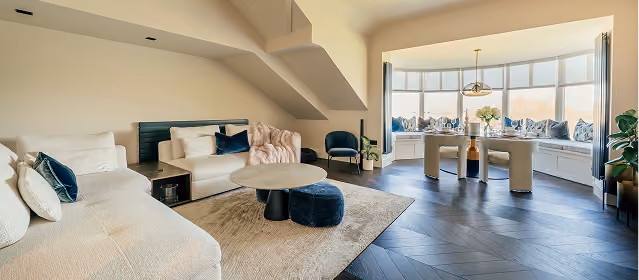 Spacious open-plan living space with sofa and panoramic windows at The Luxury Harrogate Penthouse