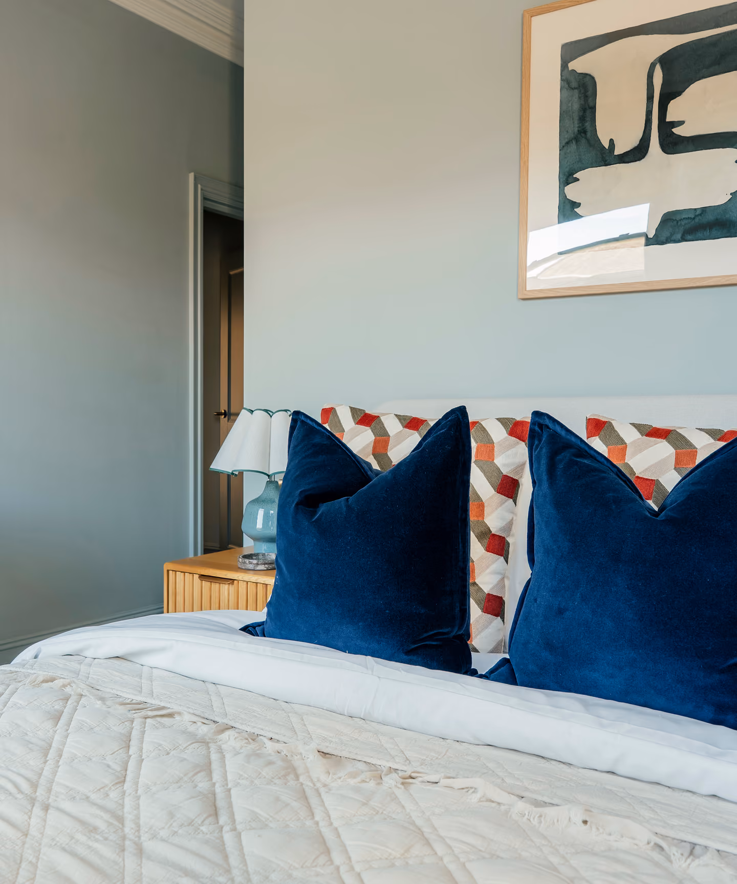 Bed with navy cushions in a Harrogate apartment bedroom