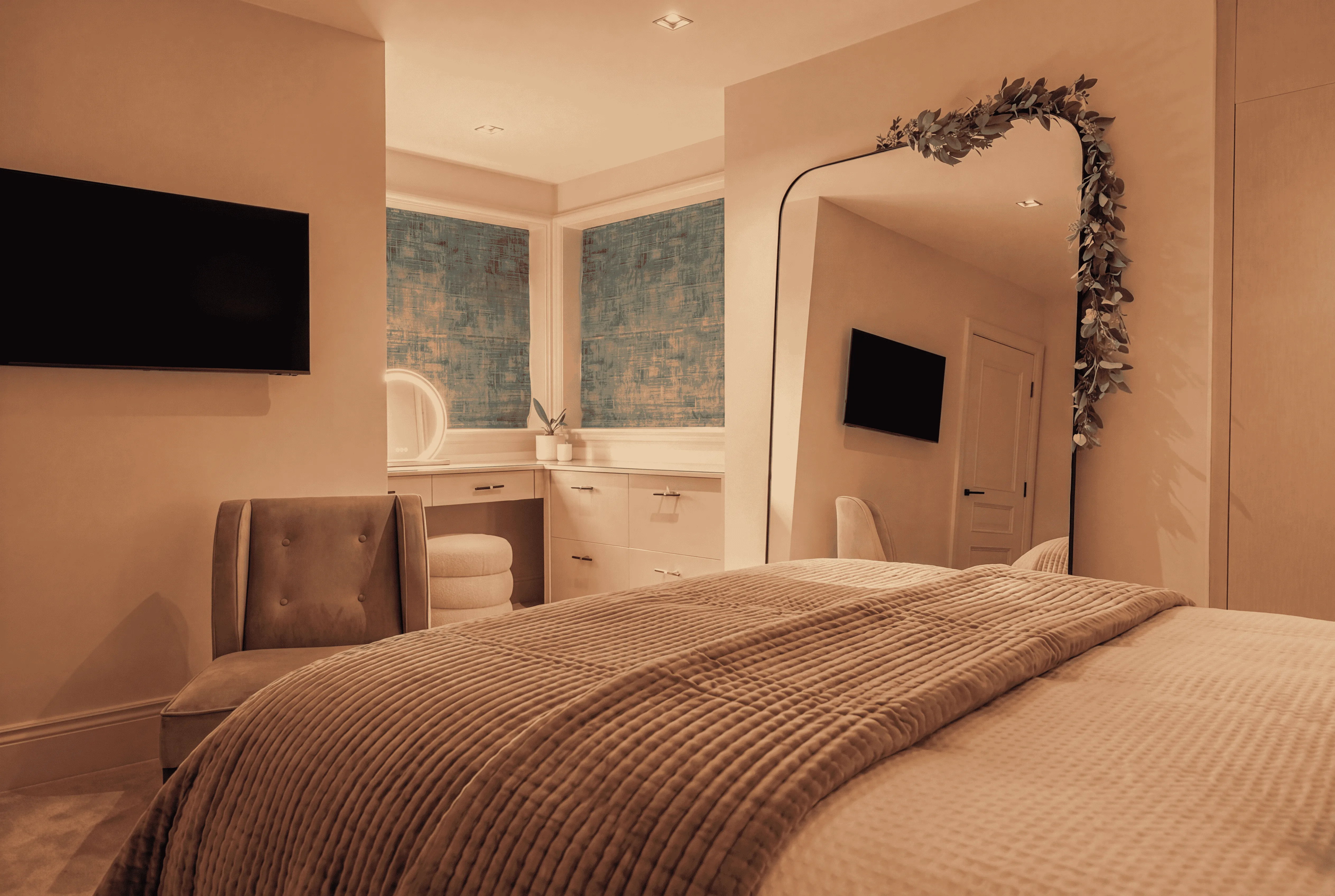 Bedroom with a large mirror and soft throws in a Harrogate short stay