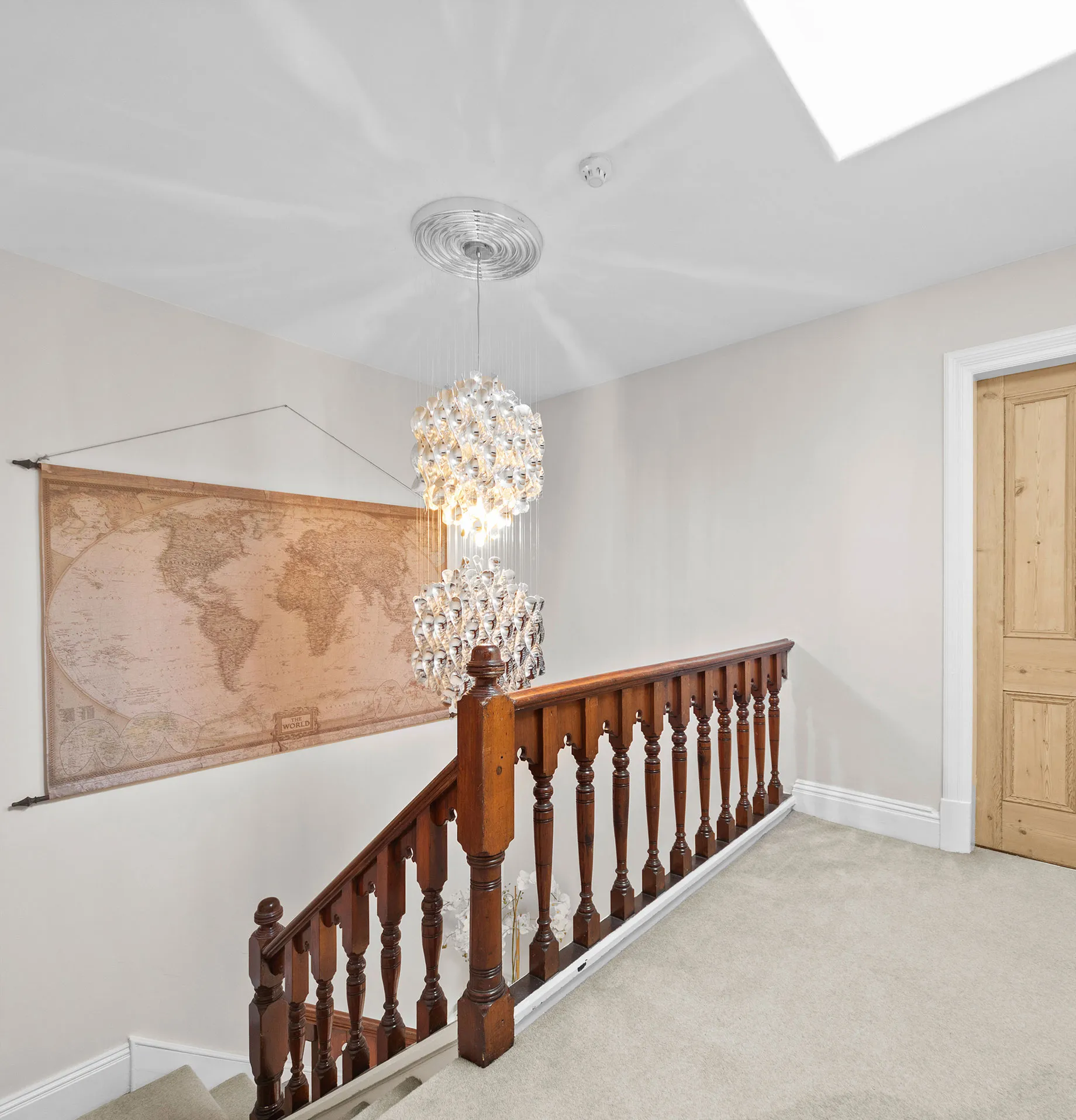 Landing with a wooden banister and vintage map in a Harrogate townhouse