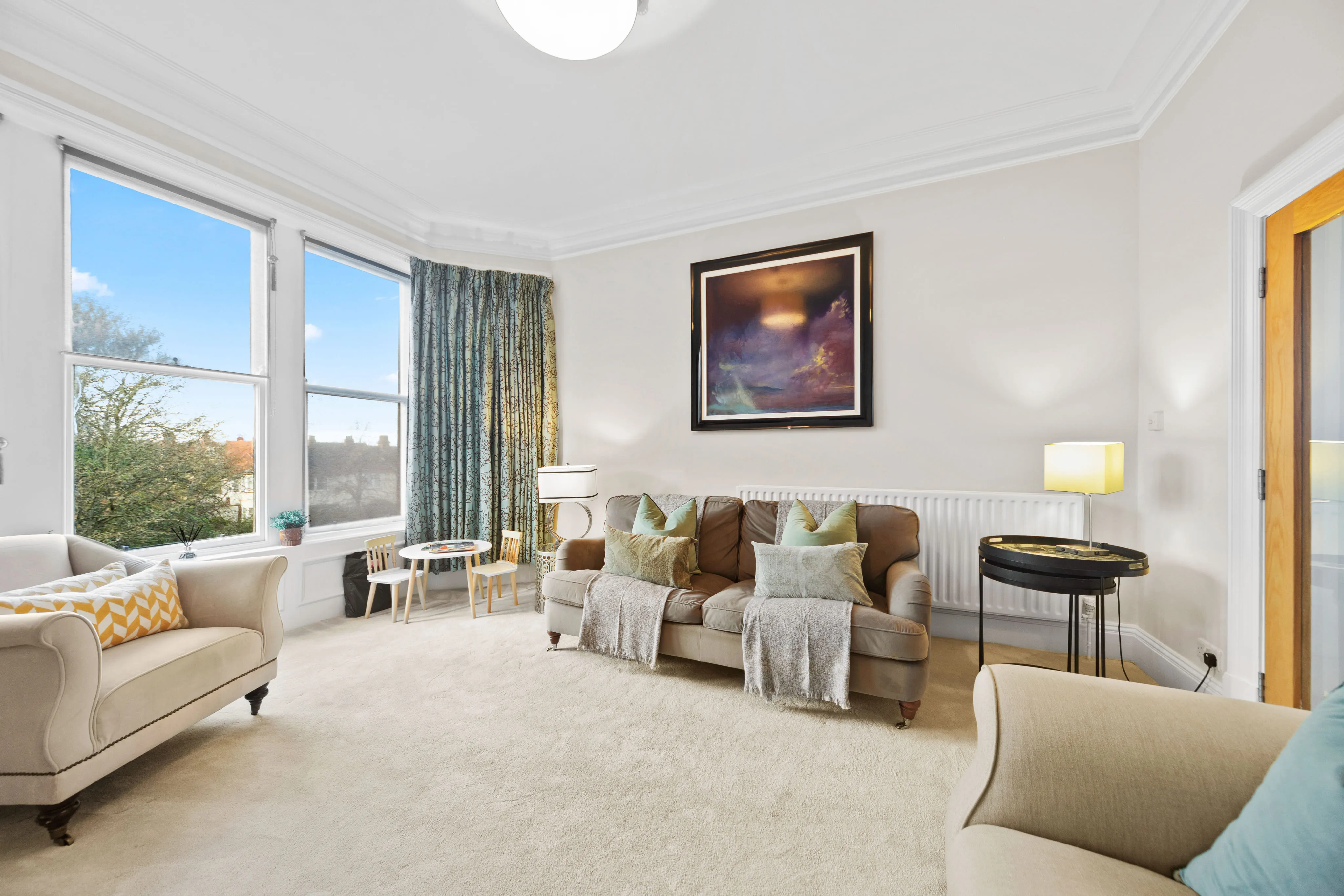 Bright living room with a bay window and cream sofas at The Royal Hall Retreat, Harrogate