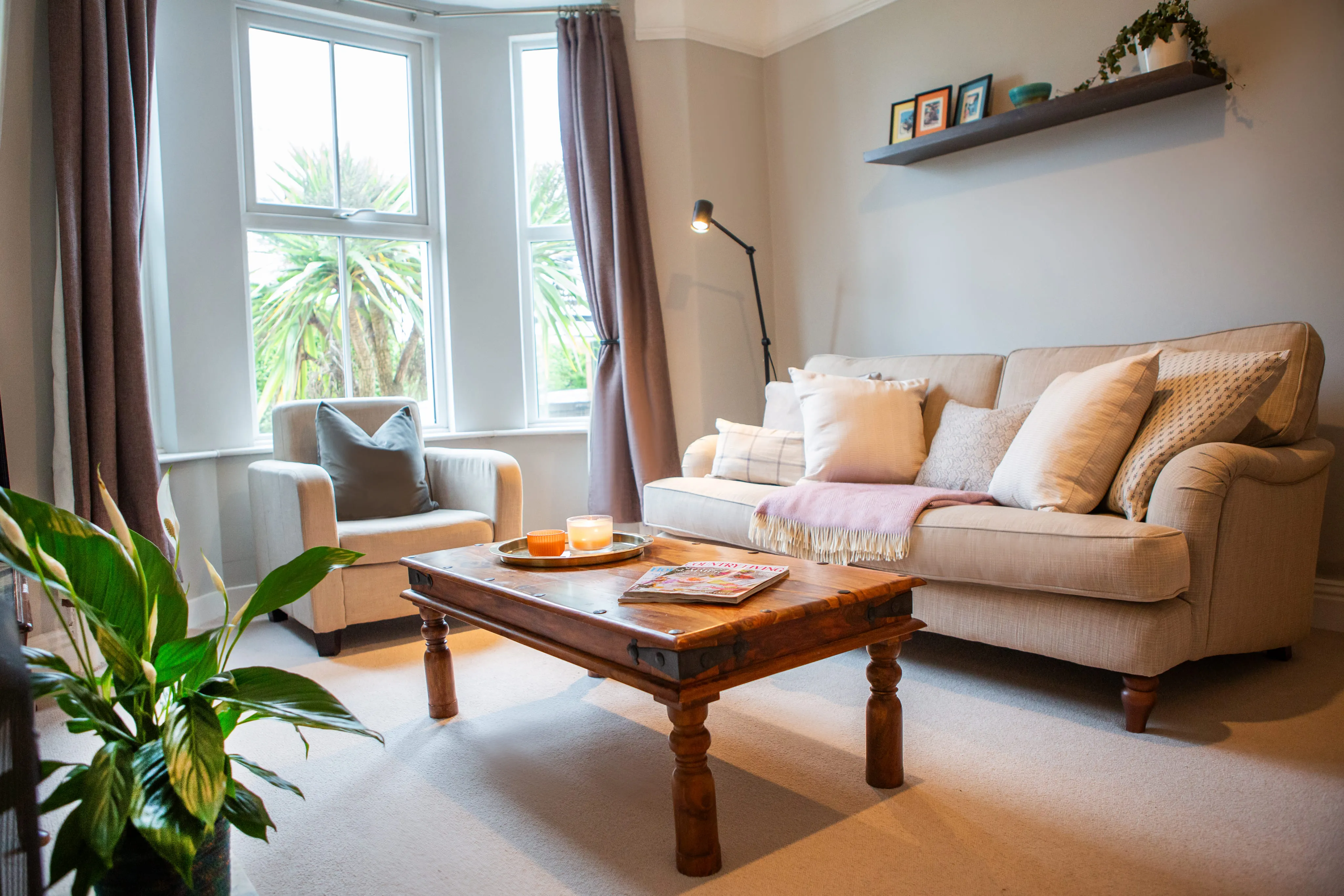Cosy living room with cream sofas and a wooden coffee table at Mount St Townhouse, Harrogate