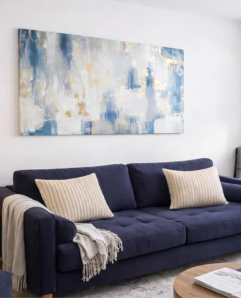 Navy sofa beneath an abstract blue painting in a Harrogate apartment