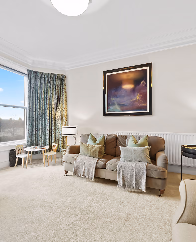 Elegant living room with cream sofas and a bay window in Harrogate
