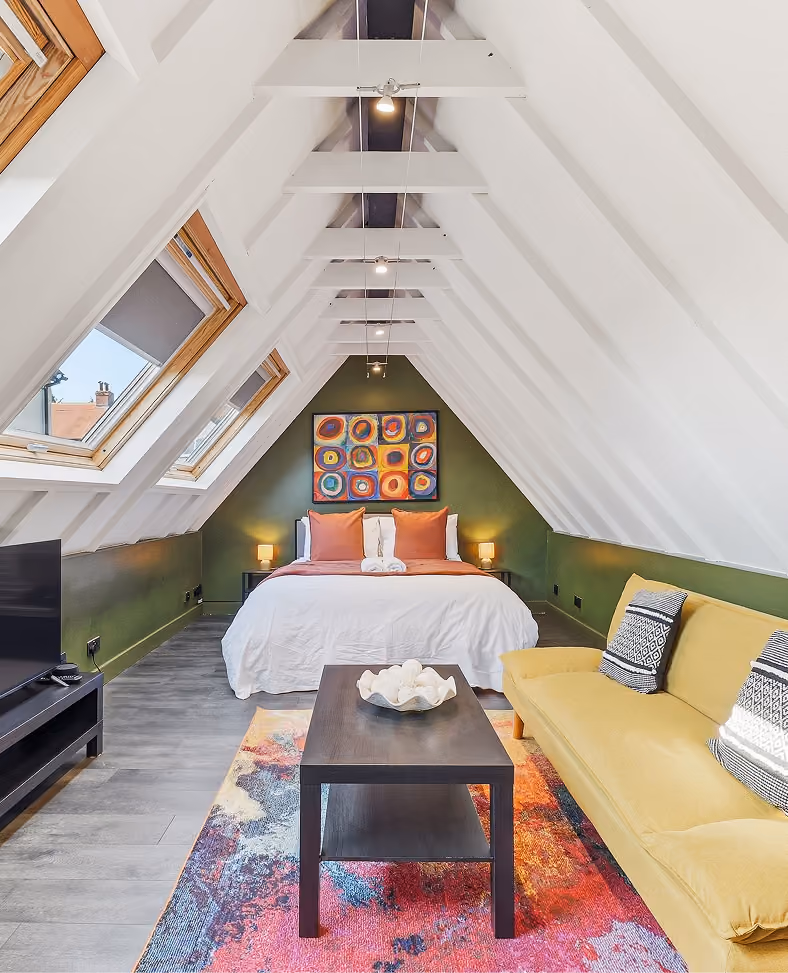Attic bedroom with skylights and colourful artwork in a Harrogate townhouse