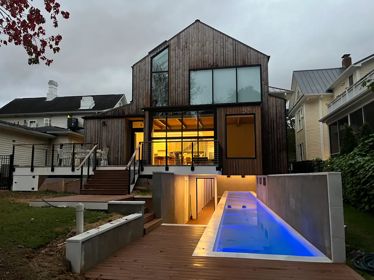 Narrow lap pool built by Kurt Candler beside a modern home at dusk