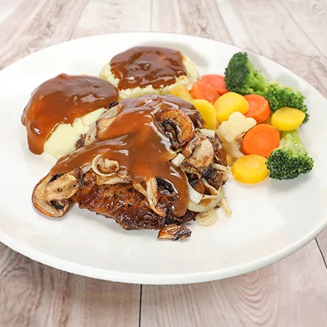 Plate with steak, mushrooms, onions, mashed potatoes with gravy, and mixed steamed vegetables.