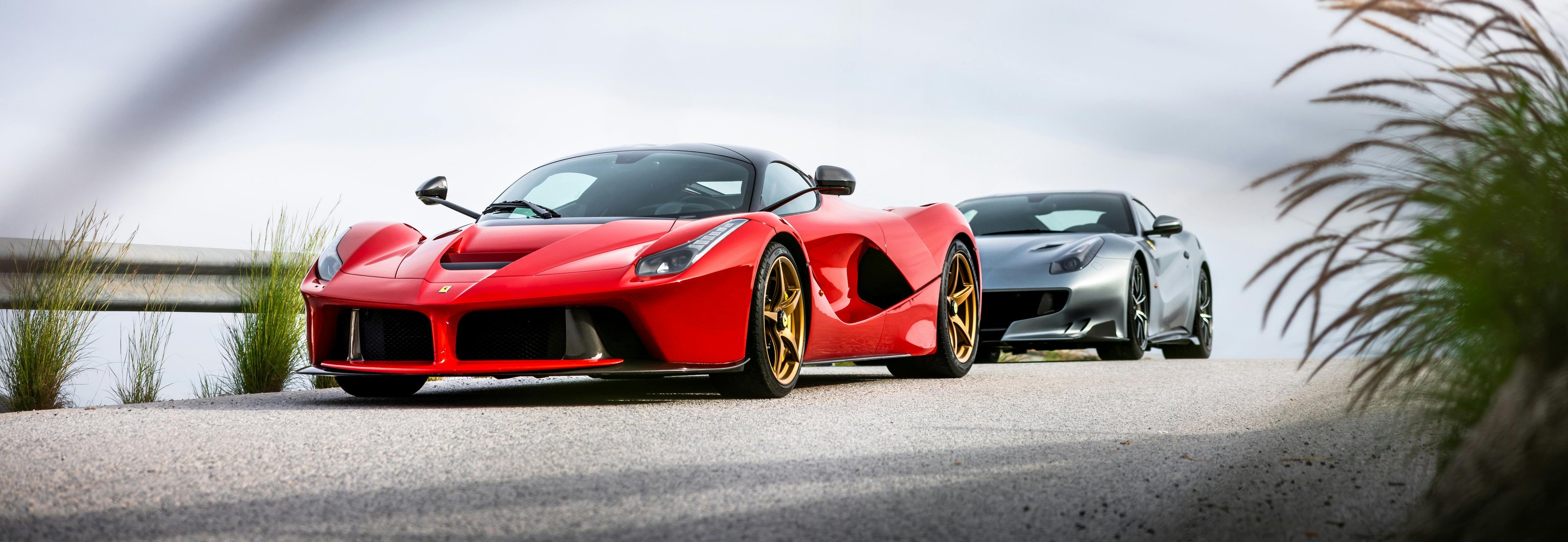 Red Ferrari LaFerrari and a grey Ferrari parked on a road
