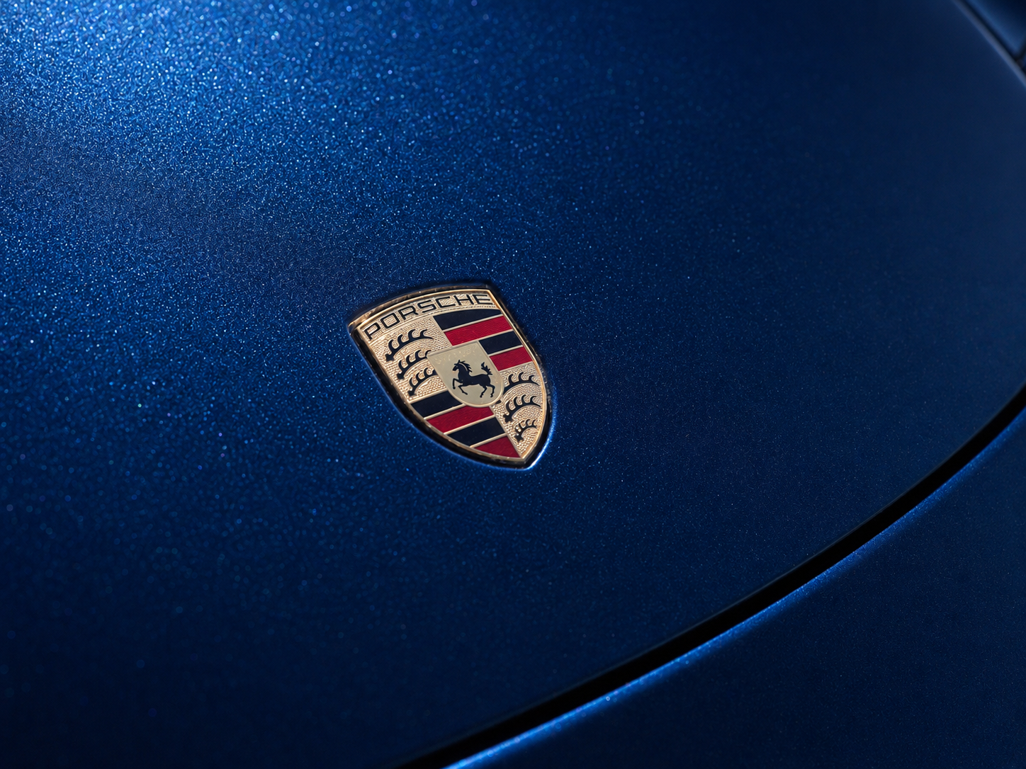 Porsche crest emblem on blue 911 Carrera hood
