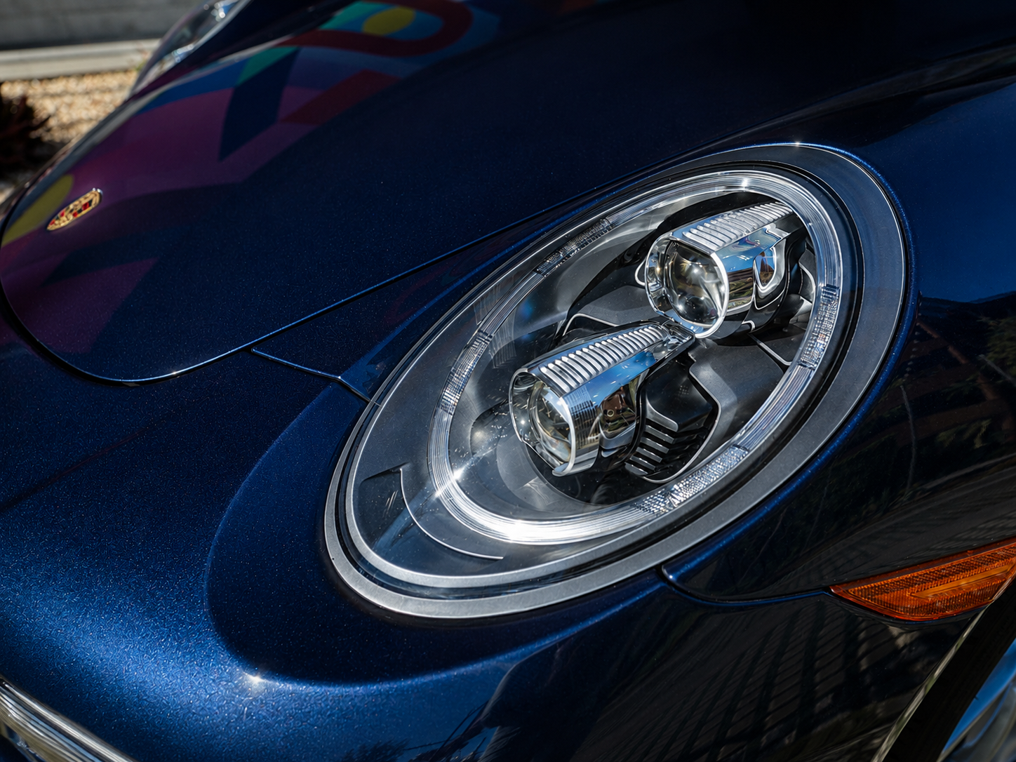 Porsche 911 Carrera LED headlight detail on blue convertible