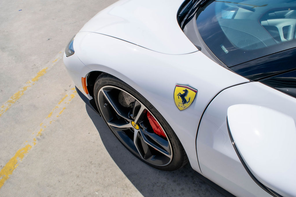 Ferrari 296 GTB rental in white, a hybrid Ferrari that pulls away on electric power